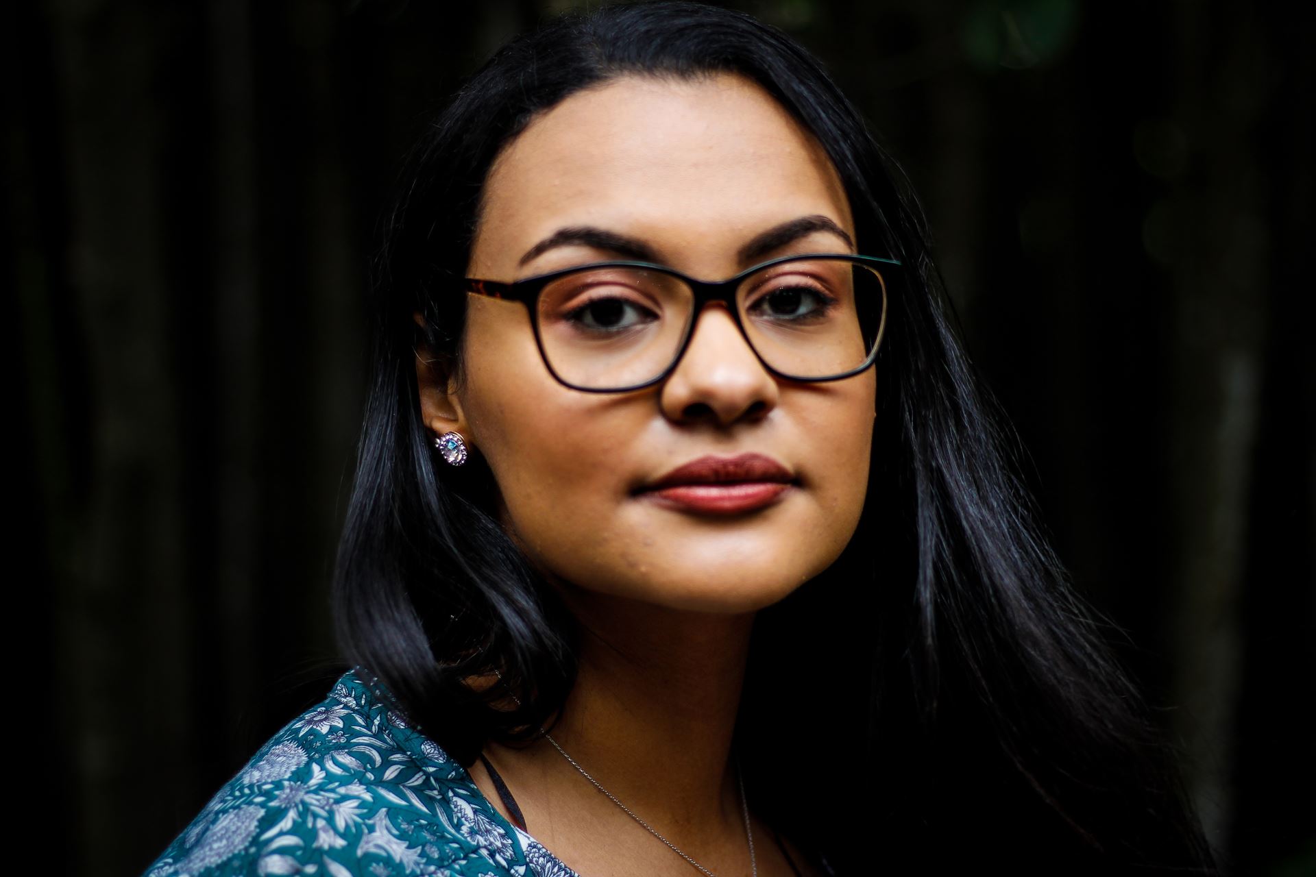 a woman wearing glasses and smiling at the camera